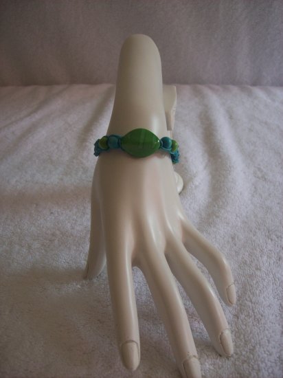 Green stone with wood beads on blue square