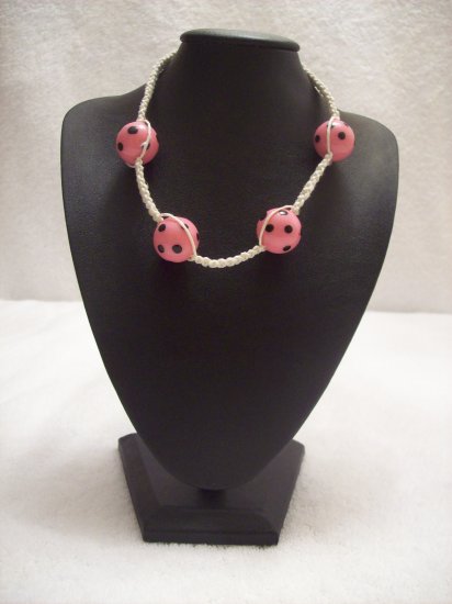 Pink and black spotted balls (4) on white square