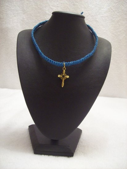 Small gold cross on royal blue square
