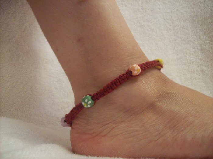 Colorful round beads (6) on burgundy square