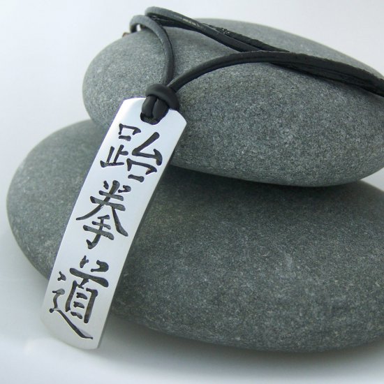Taekwondo in kanji, stainless steel pendant on natural leather cord. A surfer style necklace