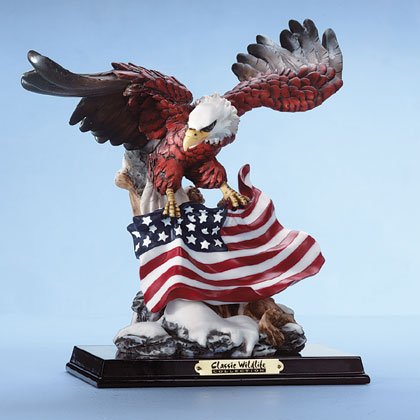 Eagle with American flag, on snow covered ledge.