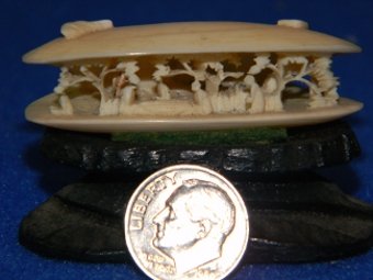Antique ivory Anabori Netsuke carving on pedestal.