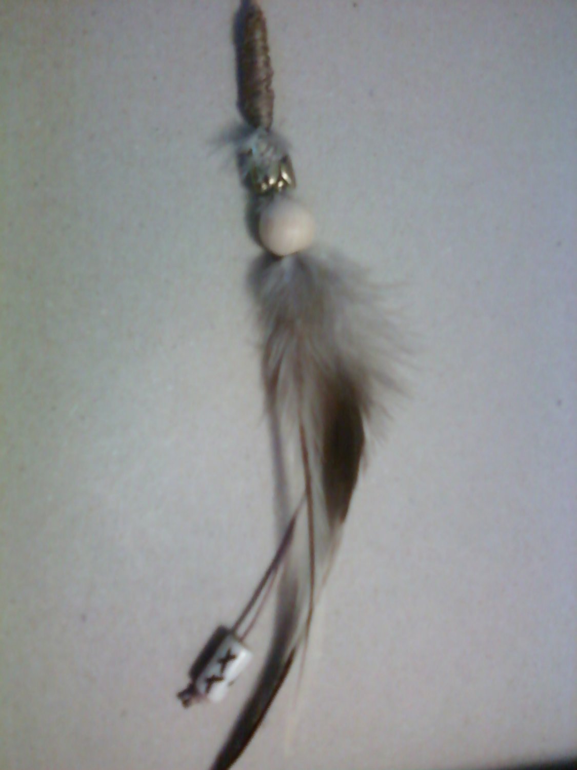 Natural colored grizzly rooster feathers with beads.
