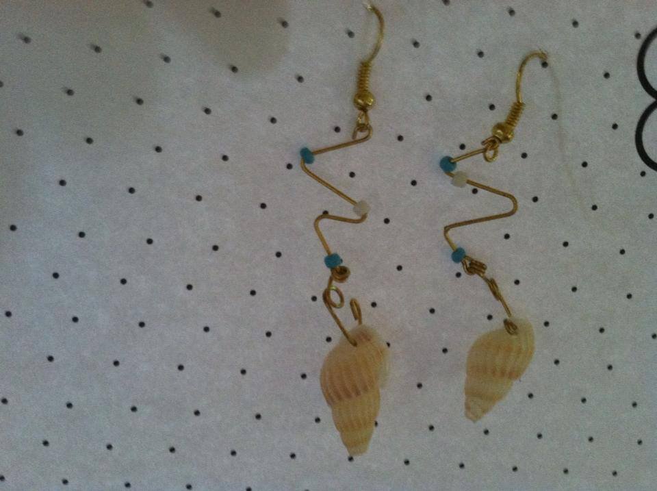 Cone shell earrings with blue and white bead accents.