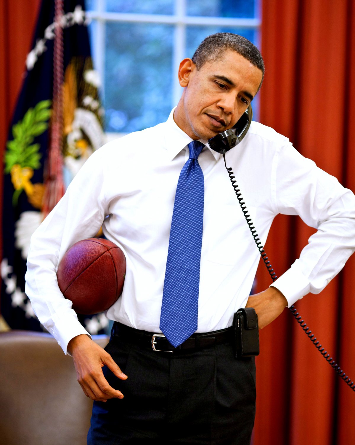 PRESIDENT BARACK OBAMA ON THE PHONE WHILE HOLDING A FOOTBALL 8X10 PHOTO (ZZ-622)