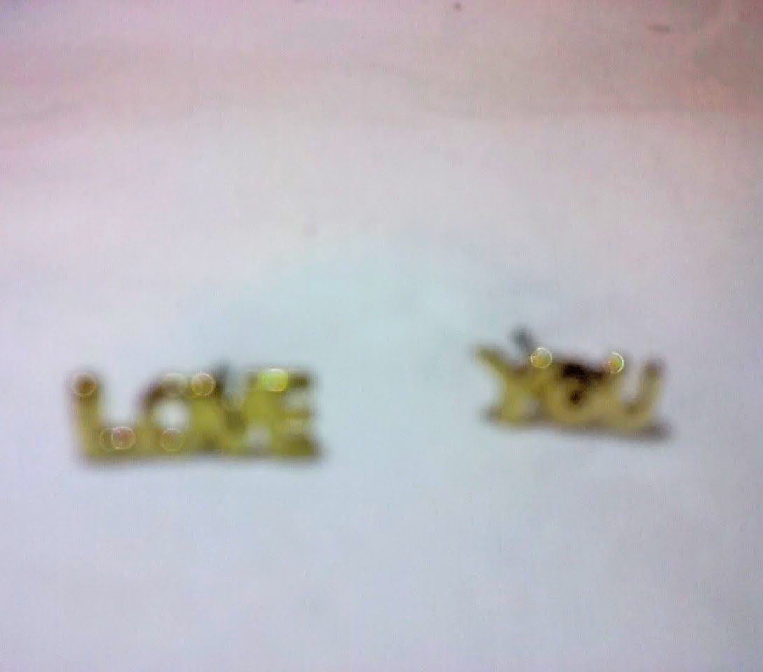 Antique style gold stud earrings one reads 'love' and the other reads 'you'