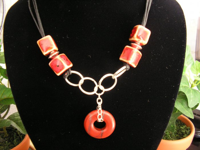 Black cord with clay and silver plated beads and findings beautiful red jasper doughnut pendant