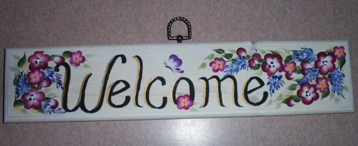 welcome sign with small burgundy & purple flowers
