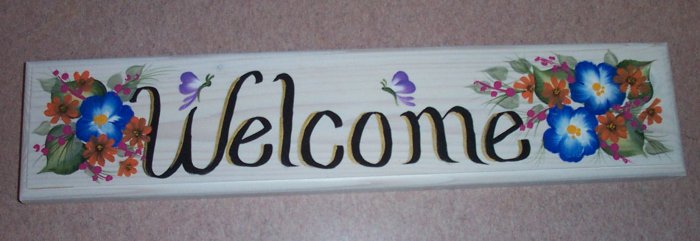 welcome sign with blue & small orange flowers