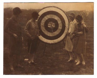 Real Photo of girls from the Marjorie Webster School examining archery target, 1926