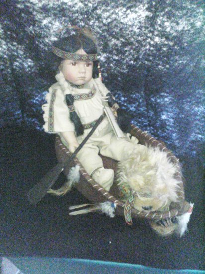 indian doll in a canoe