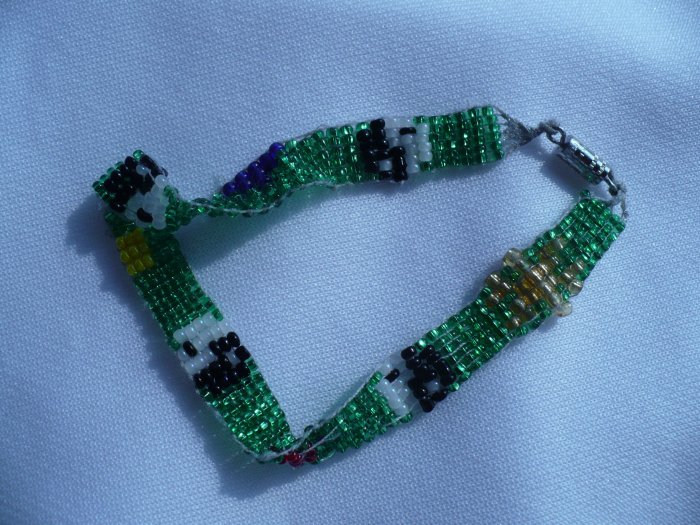 bracelet woven with glass seed beads background is green with 4 black and white yin -yang symbols