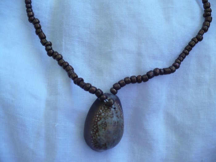 necklace made with cowrie shell and brown ceramic beads