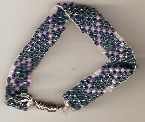 bracelet woven with blue green and white glass seed beads. design is a simple white fish shape.
