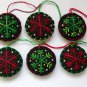 Handmade red and green snowflake felt ornaments on black lot