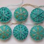 Handmade brown and blue snowflake felt ornament on aqua lot