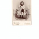 Vintage Photograph Young Girl On Fence Long Coat Bow Holding Hat On Card Stock