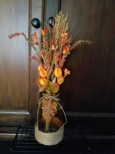 Amber Bottle, Jute & metal leaf w/ Orange buds, berries, Green, Brown & Cream Wheat w/ glass rocks