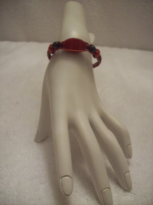 Red stone with wood beads on black and red square