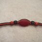 Red stone with wood beads on black and red square