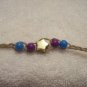 Gold star with purple and blue beads (4) on tan braid