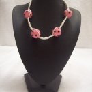 Pink and black spotted balls (4) on white square
