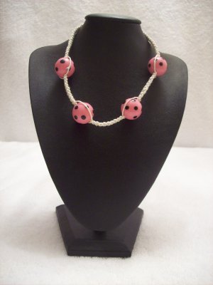 Pink and black spotted balls (4) on white square