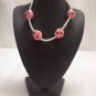 Pink and black spotted balls (4) on white square