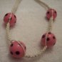Pink and black spotted balls (4) on white square