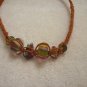 Abstract glass beads on orange square