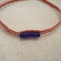 Blue beads (6, strung on) on red and white square