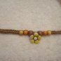 Yellow flower with wood beads on brown square