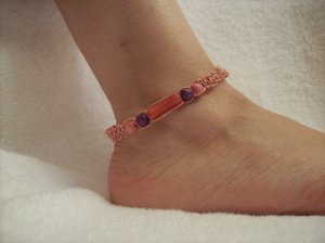 Pink cyllinder with wooden beads on pink square