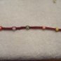 Colorful round beads (6) on burgundy square
