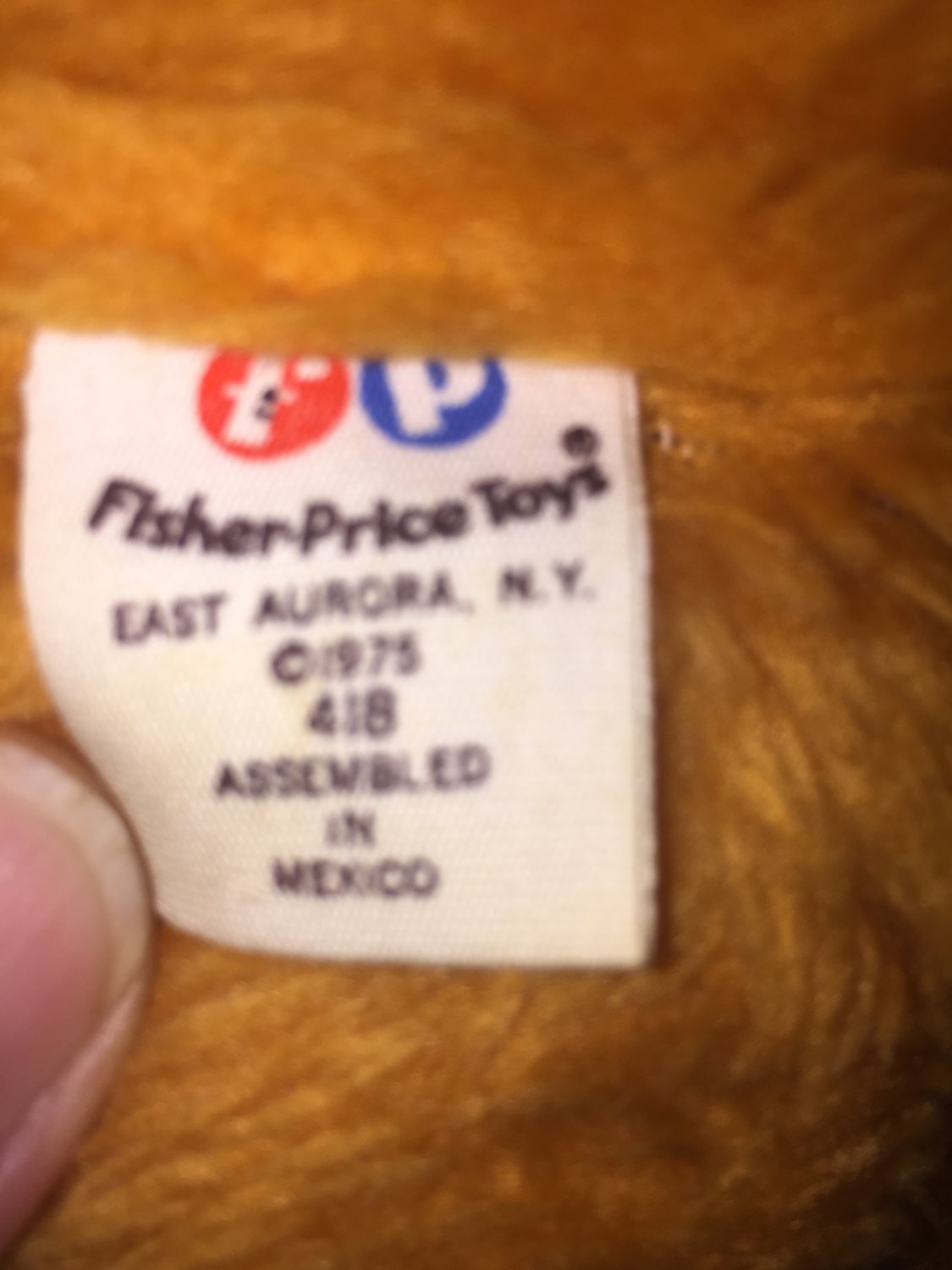 orange teddy bear with apple bib