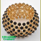 Designer inspired bracelet flaunts a goldtone finish and acrylic jet black stones.