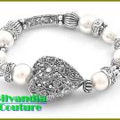 Designer inspired bracelet flaunts a silver finish, detailed heart with white faux pearls.