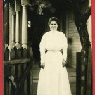RPPC WOMAN STANDING  GATE HOUSE WAITING AT THE GATE