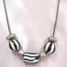 1043NN Zebra striped bead Necklace on tube cord. Length 16"