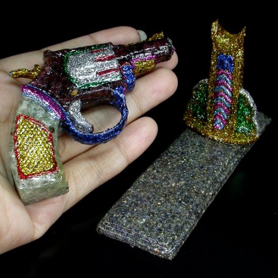 665CTS UNHEATED RHODOLITE GARNET, ZIRCON & SAPPHIRE GUN FIGURINE