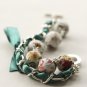 White floral fabric beads and emerald satin ribbon bracelet