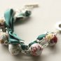 White floral fabric beads and emerald satin ribbon bracelet