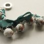 White floral fabric beads and emerald satin ribbon bracelet
