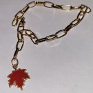 gold bracelet with maple leaf charm