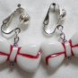 White bow w/red line clip on earring