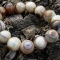 The sardonyx bracelet. 14 mm, 15 beads, irregular pattern. The rubber bands strung.