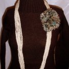 Handmade Infinity scarf/ necklace in a cream with a large multi colored pom-pom