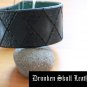 Dark green leather cuff with hand tooled argyle design