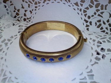 Brassy vintage hinged clamper cuff style bangle bracelet with 6 blue rhinestones in goldtone
